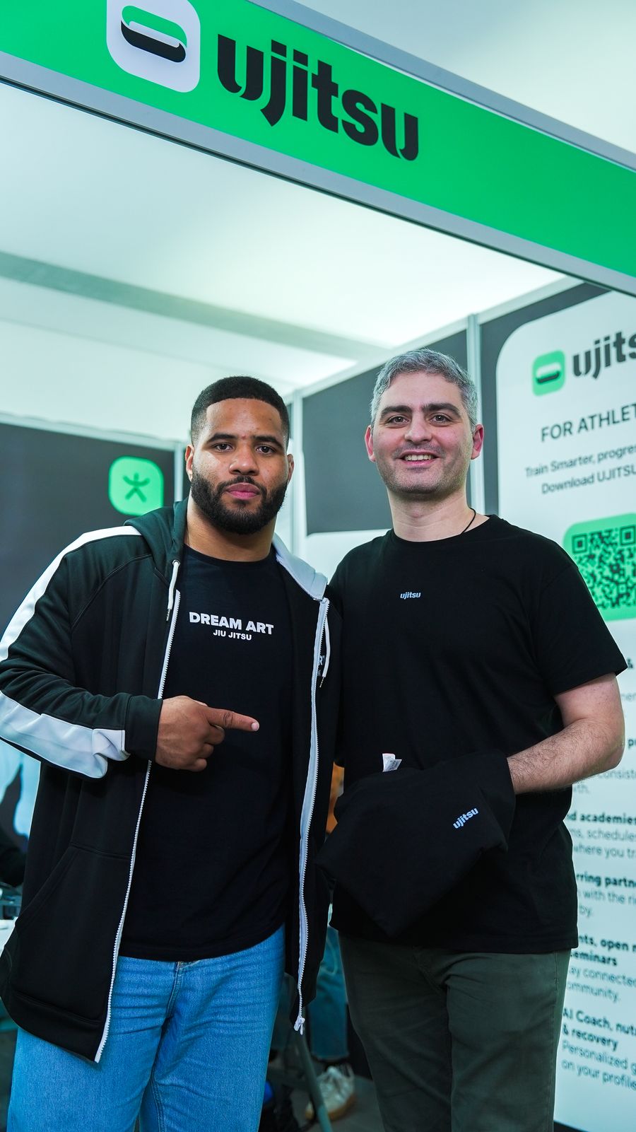 Atleta e representante de marca juntos no estande da marca em um evento